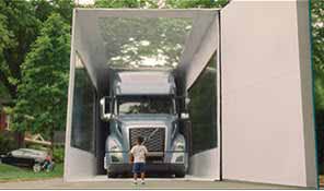 a kid standing in front of Volvo Truck VNL - SocialMedia